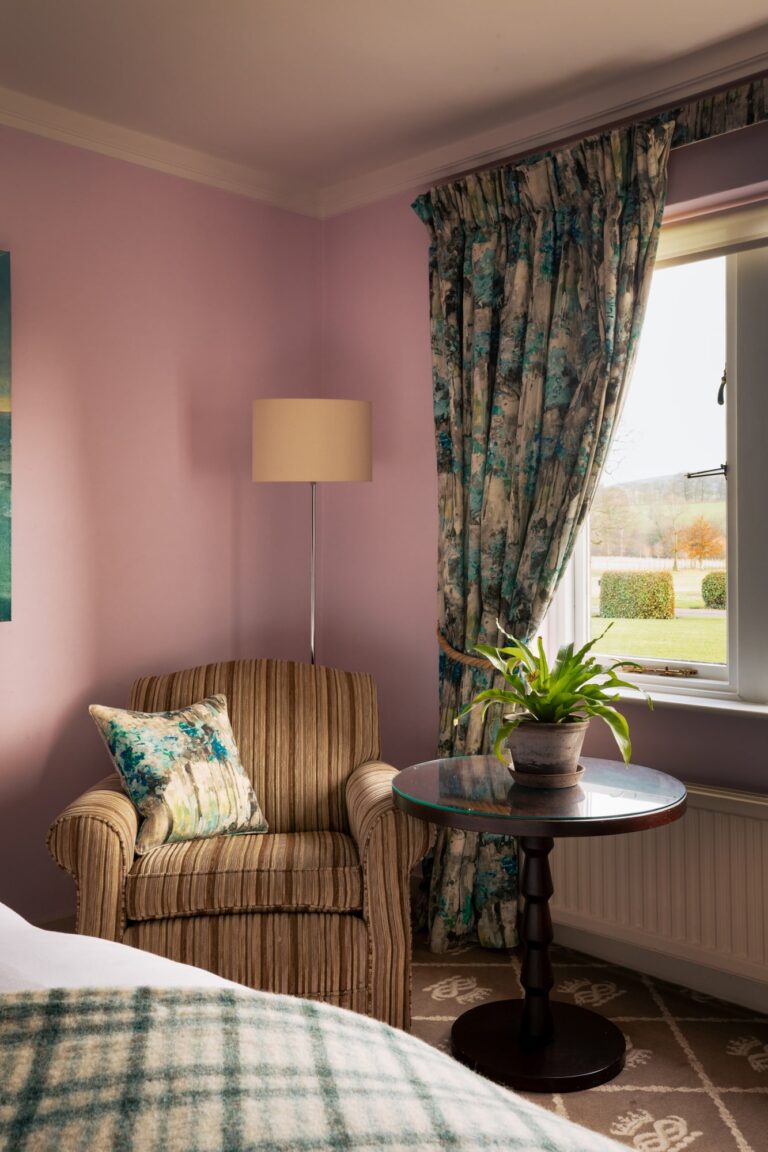 A pink bedroom with view over the rolling hills, with blue furnishings.