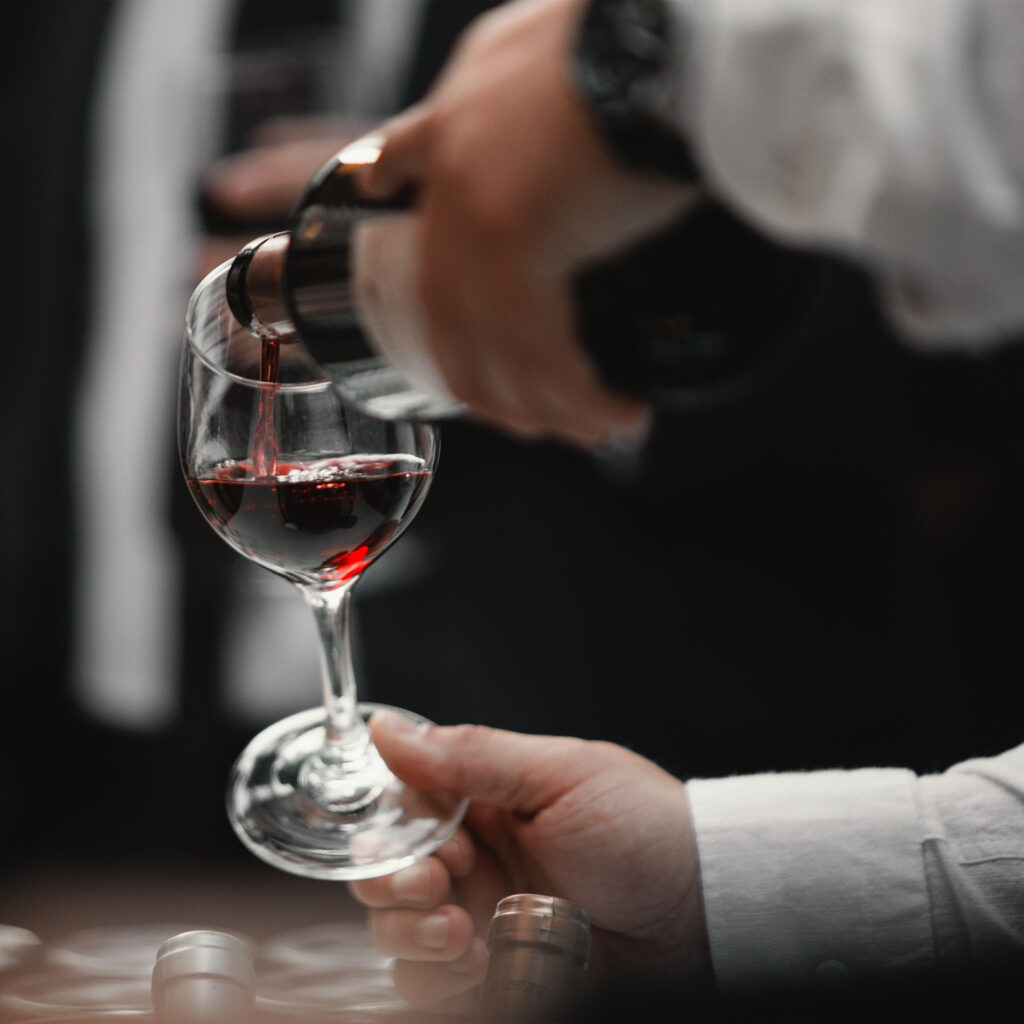 A man pours red wine into a glass.