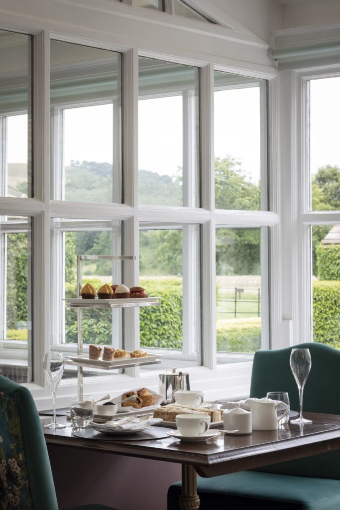 A table is set with afternoon tea on it with views into the Italian Garden.