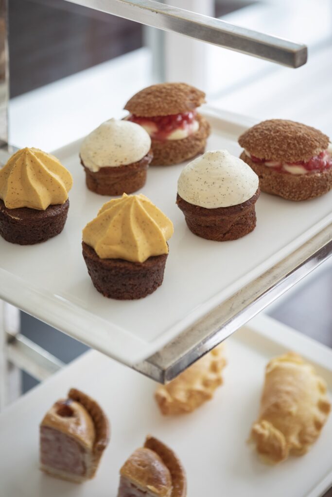 A table is set with afternoon tea on it with views into the Italian Garden.