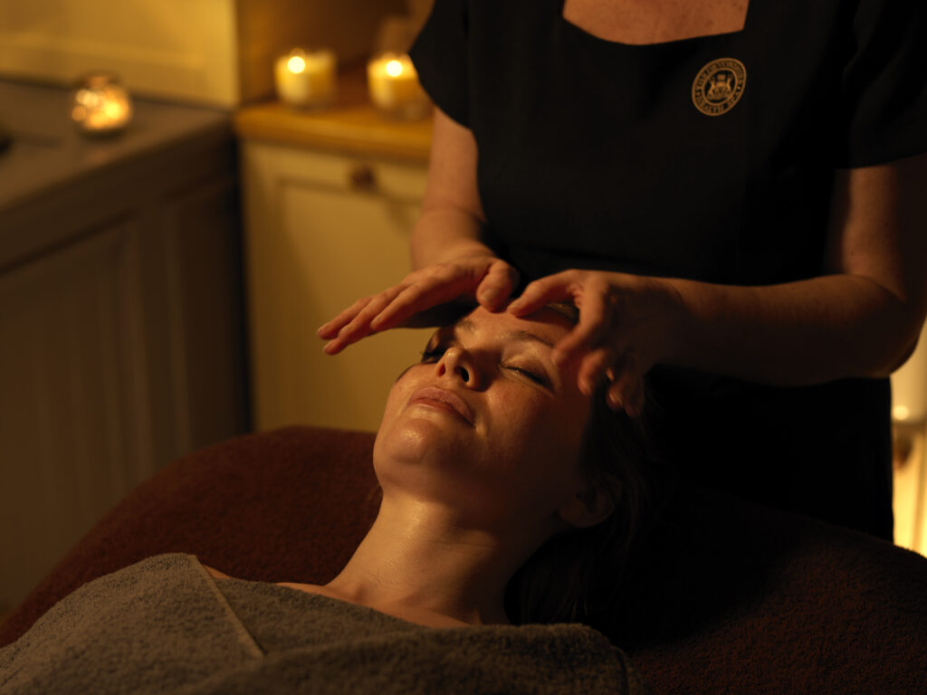 A massage is taking place with candles in the background.