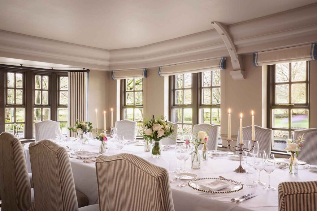 large wedding reception table set for 10 guests showing wide windows and floral decor