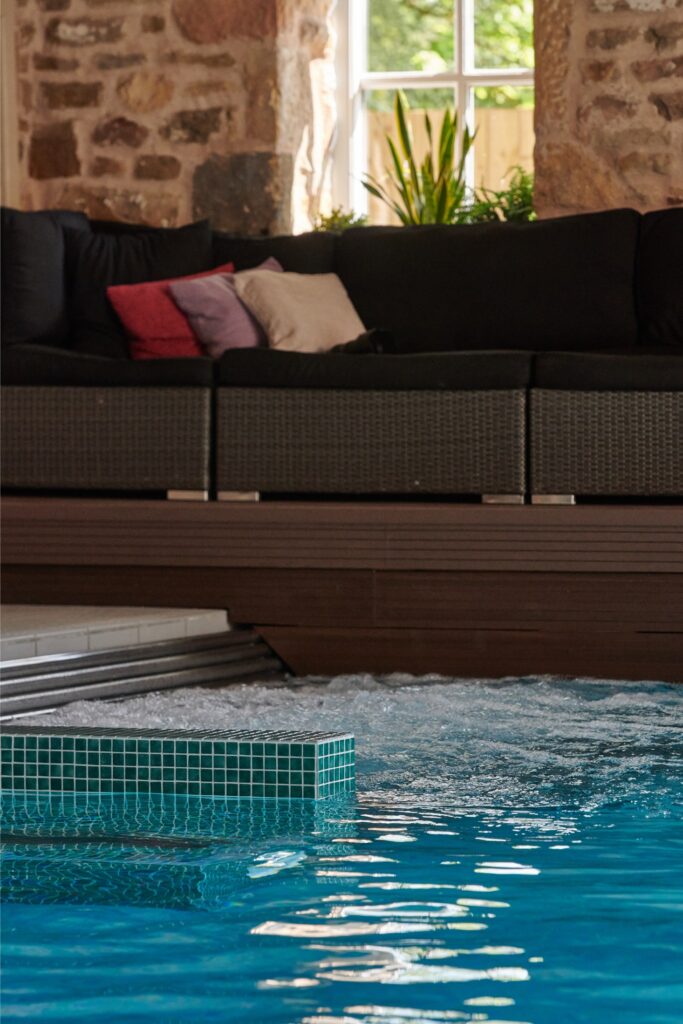 The spa pool with the bubbling water jets and the traditional stone wall behind.