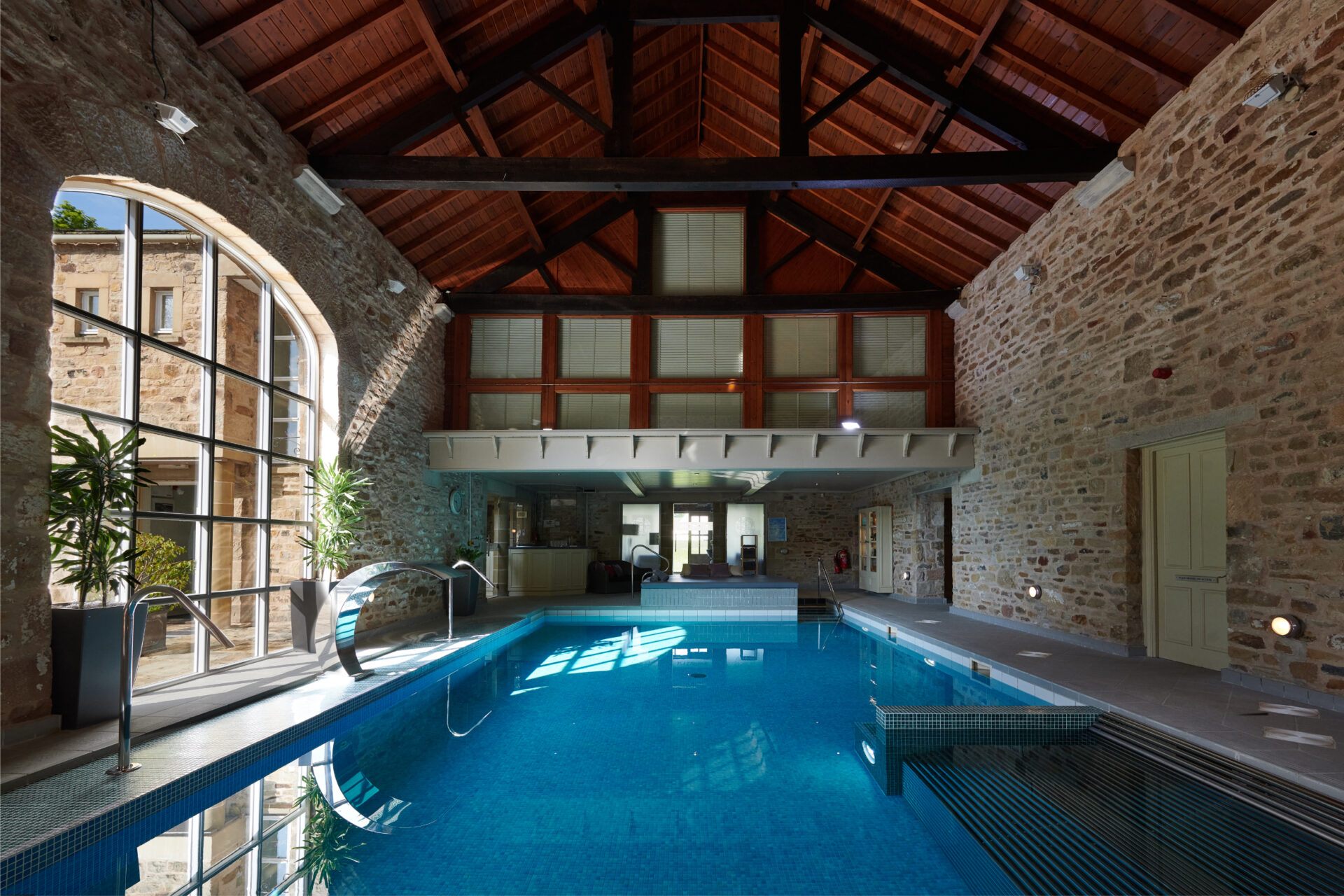 The spa pool with the bubbling water jets and the traditional stone wall behind.