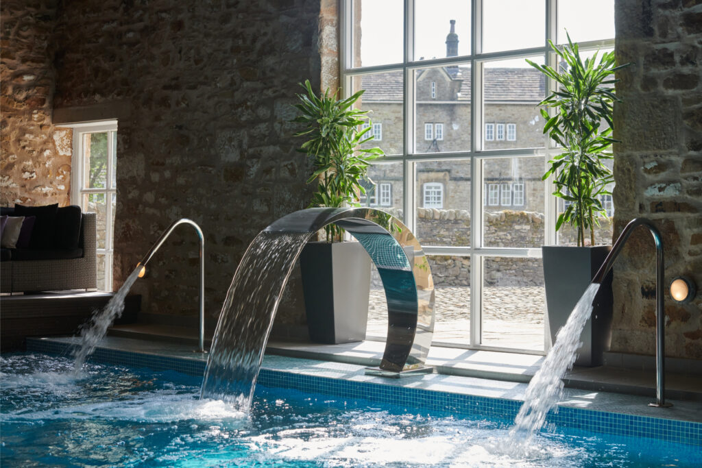 The spa pool with the bubbling water jets and the traditional stone wall behind.