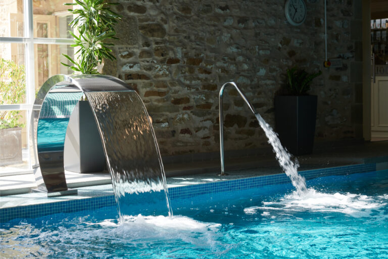 A pool area with water jets and bubbling features, and a small seating area.