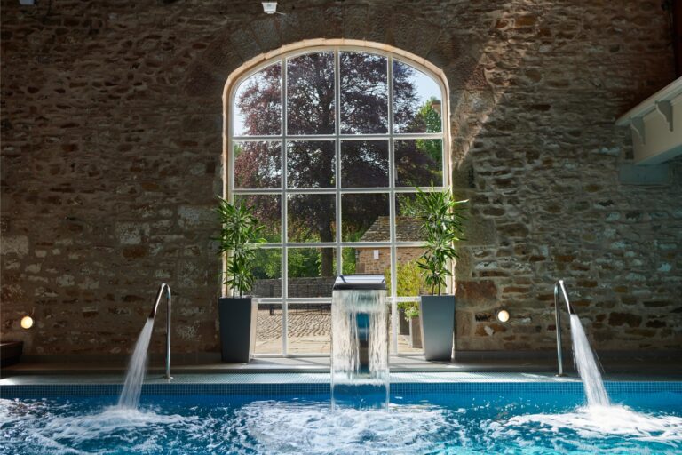 large arched windows and swimming pool in front with jets