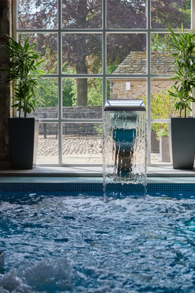 The spa pool with the bubbling water jets and the traditional stone wall behind.