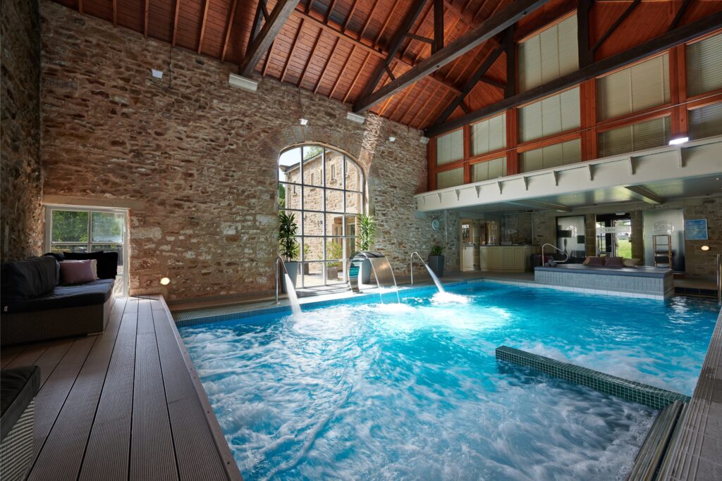The spa pool with the bubbling water jets and the traditional stone wall behind.