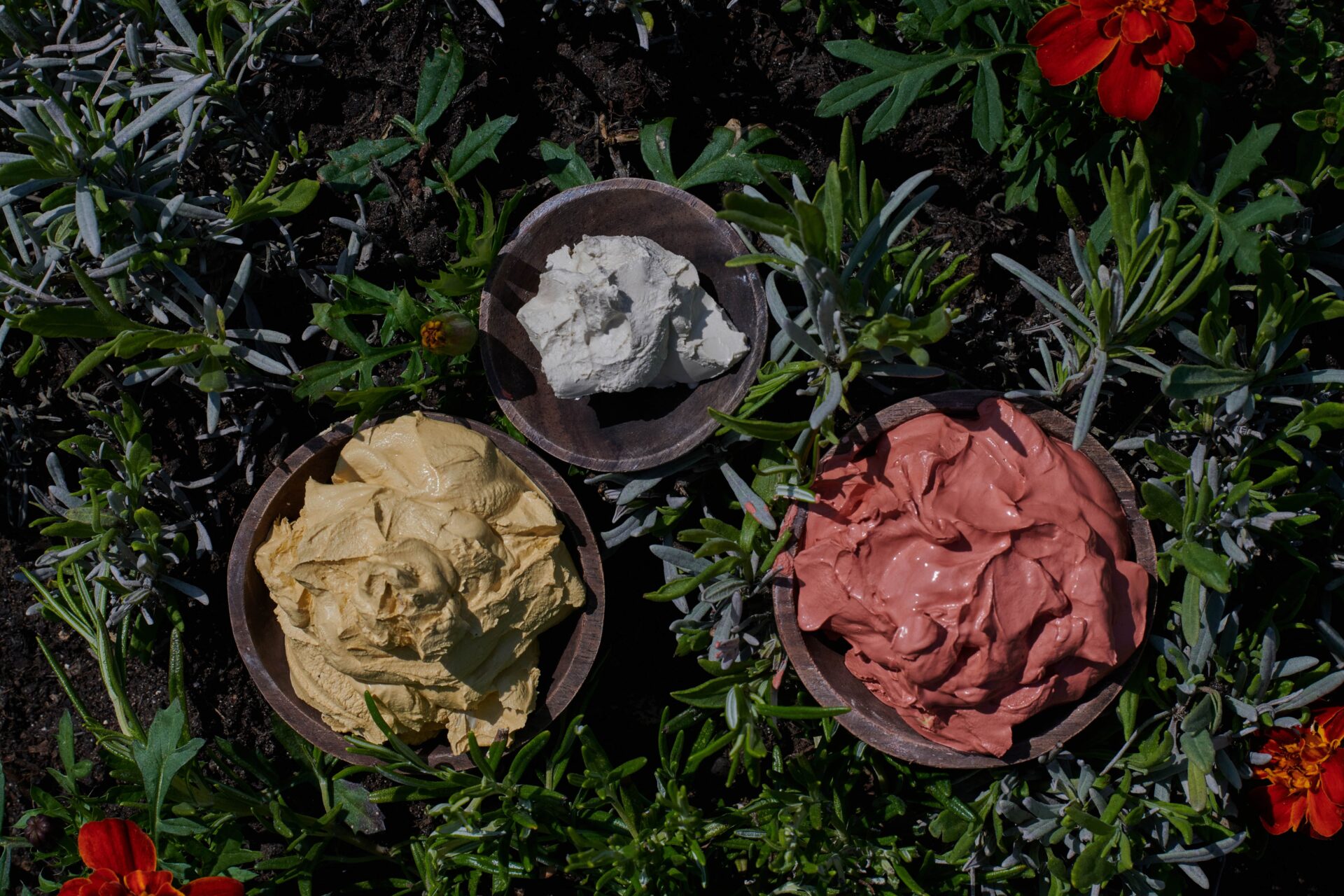 Close up image of three rasul mud bowls nestled on grass