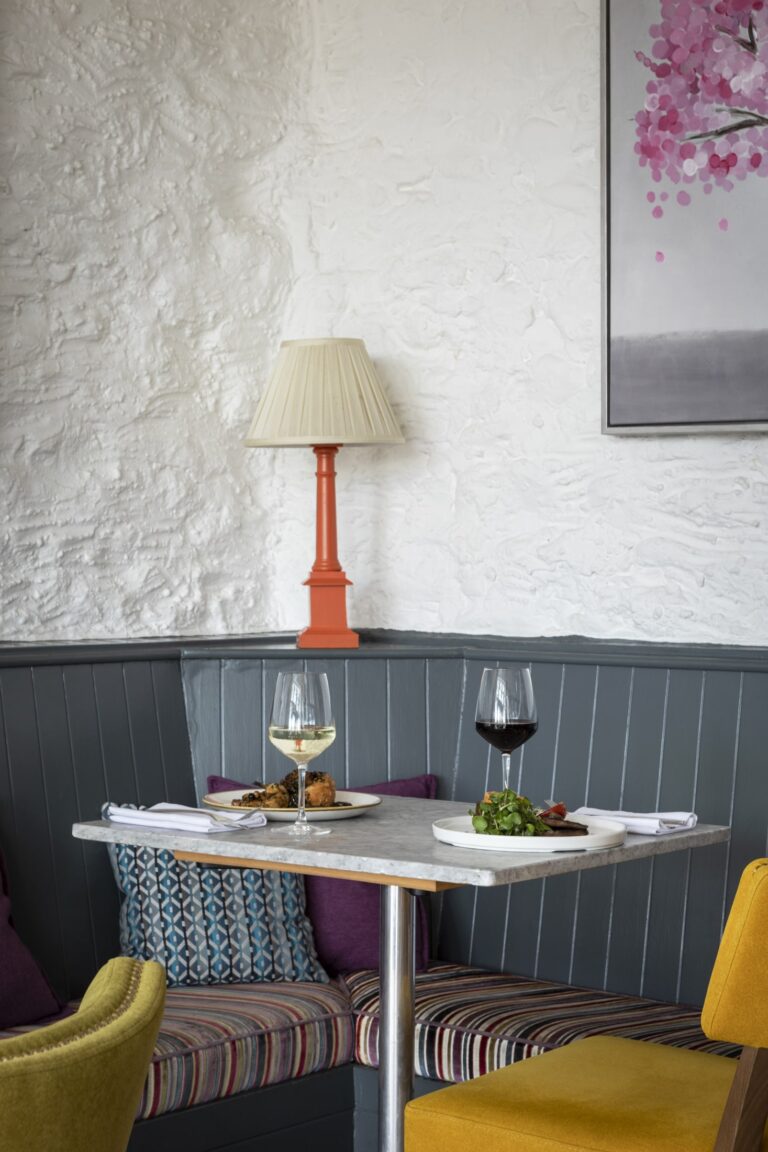 A table of food is set in the corner with yellow chairs.