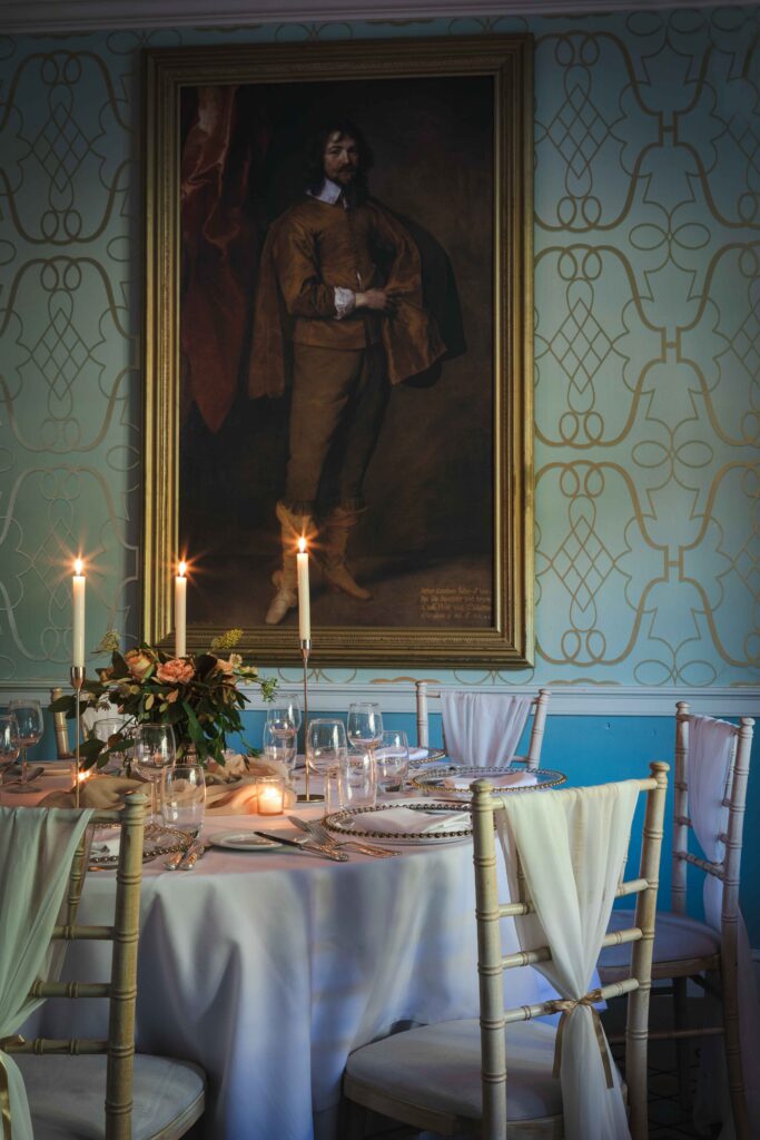 wedding ceremony room featuring candles, oil painings and blue patterned wallpaper
