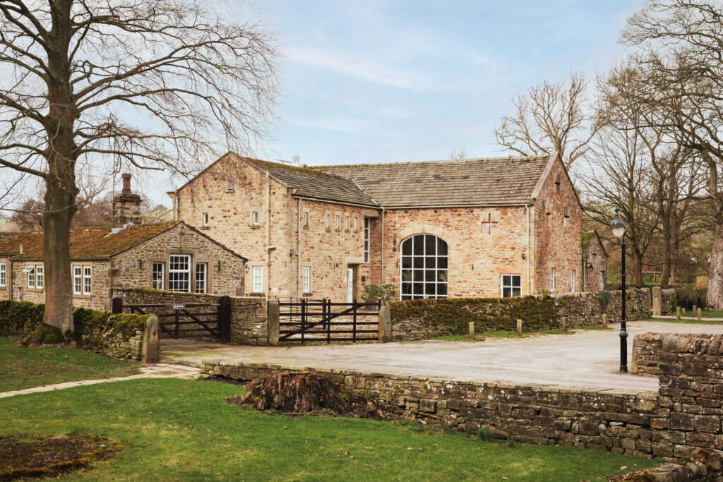 The traditional stone building surrounded by the trees nearby.