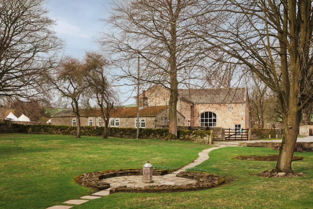 A path leads towards the traditional stone spa building and the spa tents are in the background.