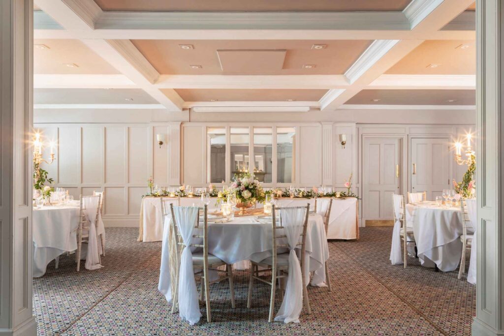 wedding reception room with panelled walls and round tables