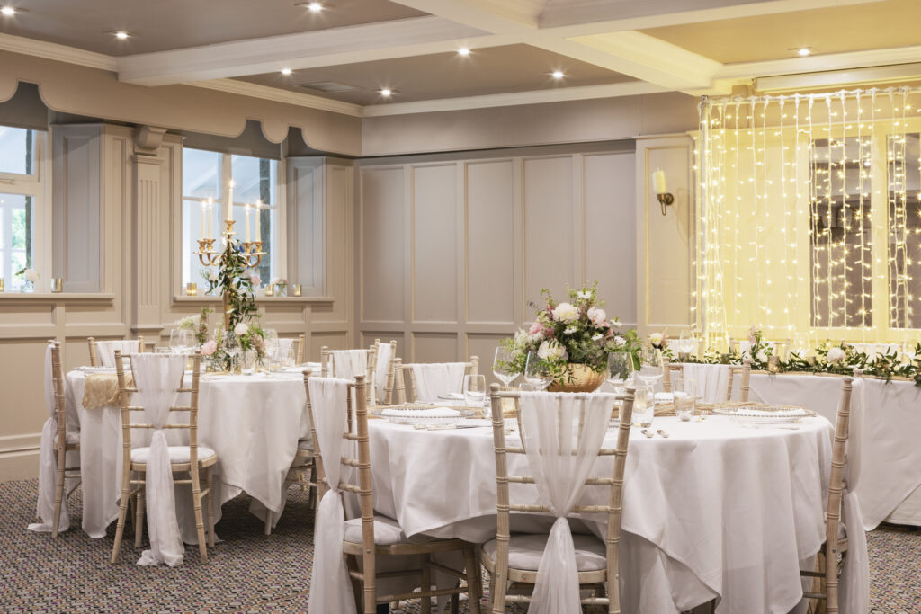 wedding reception room with panelled walls and round tables