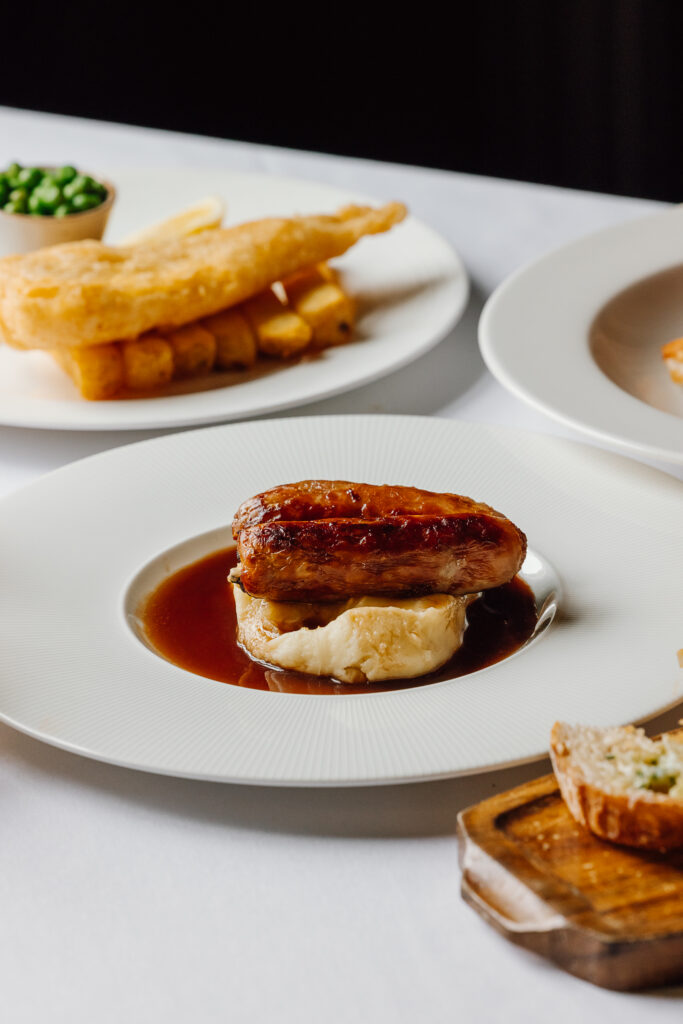 Small plate of sausage and mash, fish and chips