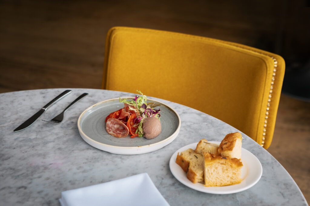 Chicken Liver parfait sat on a grey marble table and yellow table behind.
