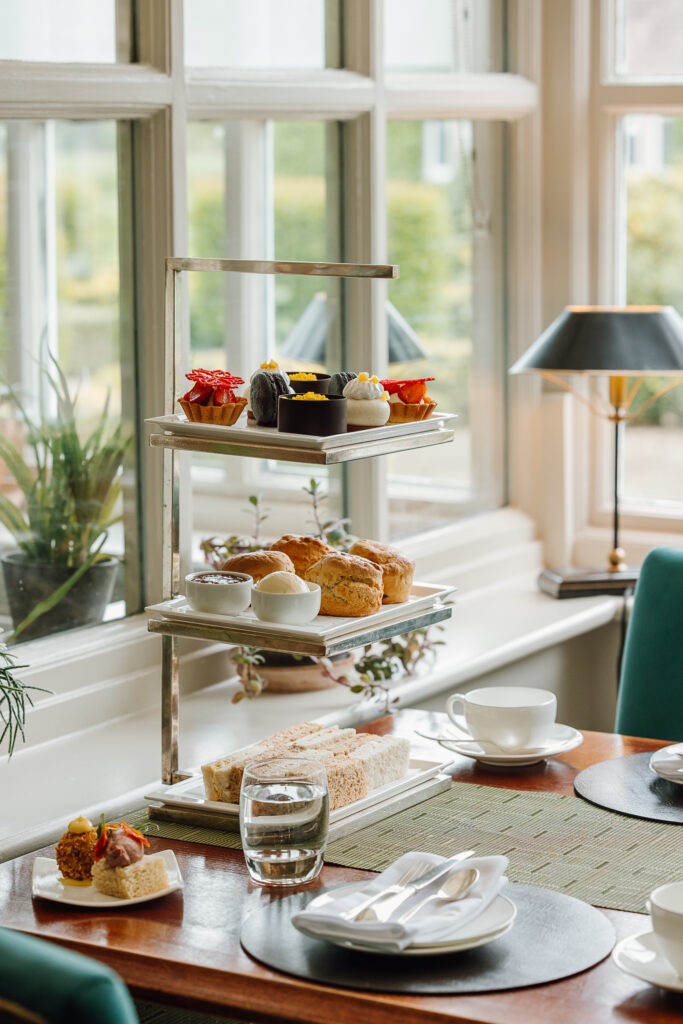 A luxurious afternoon tea stand filled with sandwiches, sweet treats and scones.